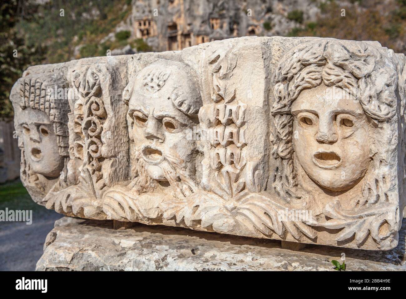 old stone masks used in theater actors in the rock tombs in Myra ancient city of Antalya in Turkey. Stock Photo