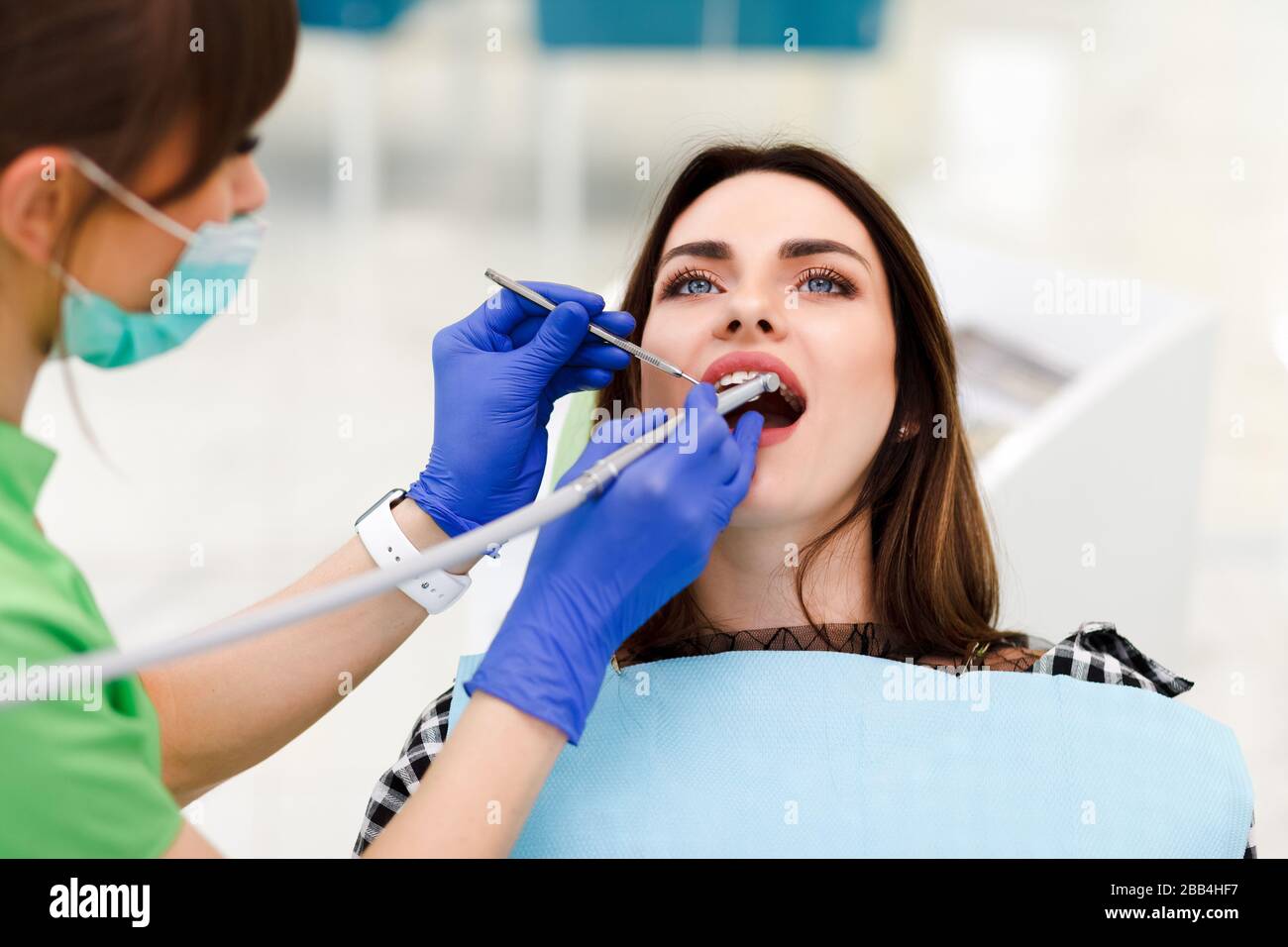 Dentist doctor drills teeth with a drill to a young woman. Girl at the dentist's appointment Stock Photo