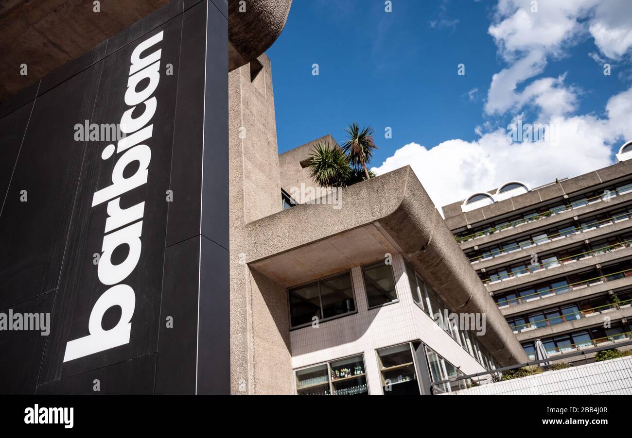 The Barbican Centre, London. Logo branding signage and the iconic Brutalist architecture of the Barbican Estate in the background. Stock Photo