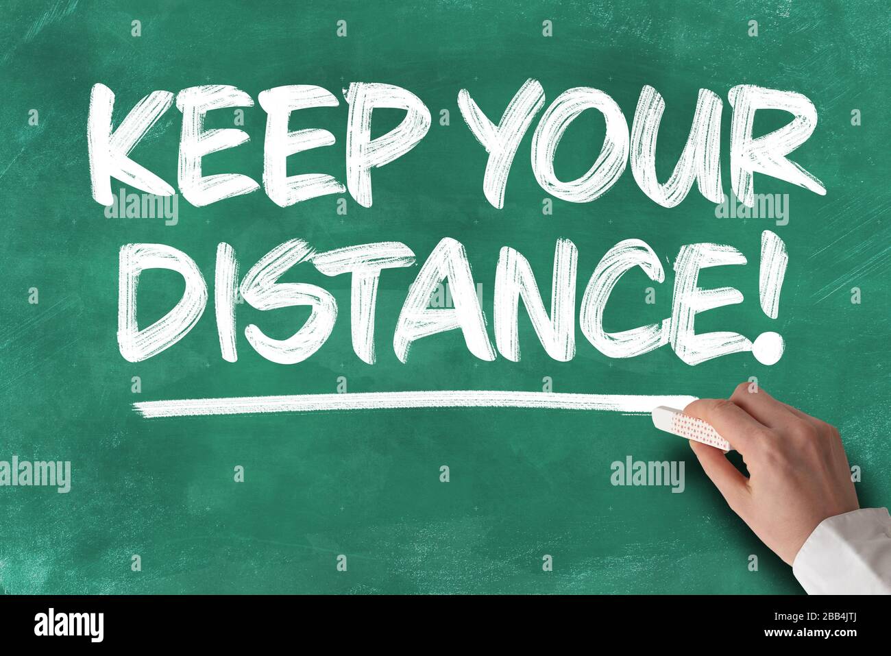 text KEEP YOUR DISTANCE written on green chalkboard, social distancing concept during covid-19 coronavirus pandemic Stock Photo