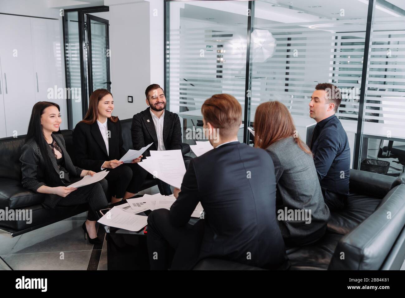 Teamwork. team discussing something and smiling while sitting at the office table Stock Photo