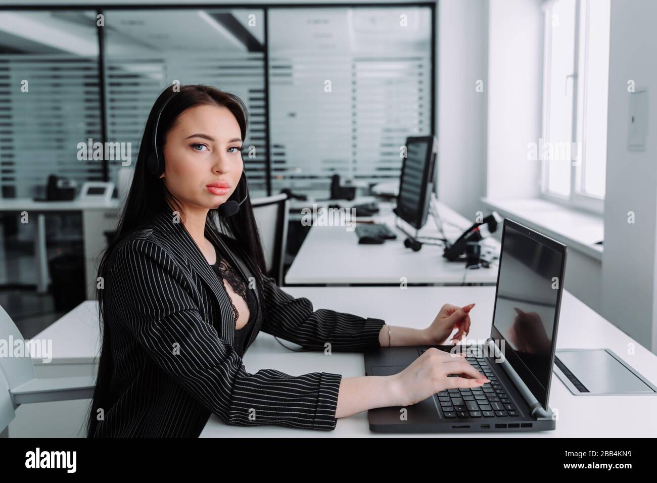 A young employee working with a headset and accompanying team Stock Photo