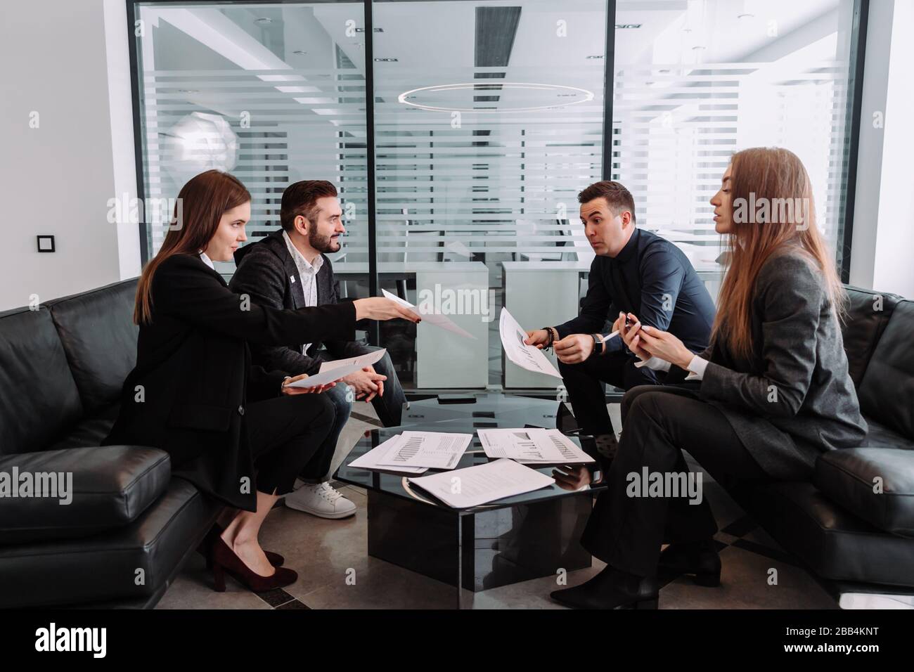 Male and female professionals having discussion at table in new office Stock Photo