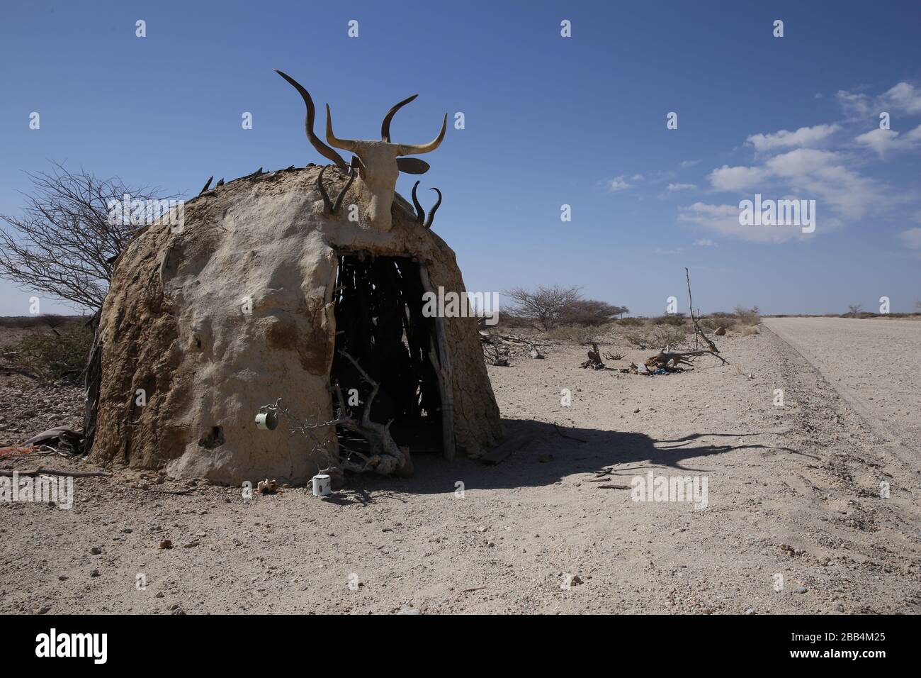 Hut made from sticks and mud at the side of a road in Namibia Stock Photo