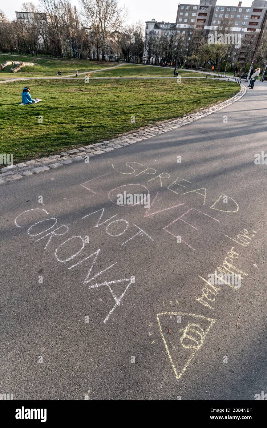 Görlitzer Park in Zeiten von Corona. 'Spread love not Corona' Verbreite Liebe statt Corona mit Kreide auf den Asphalt geschrieben, Berlin Kreuzberg Stock Photo