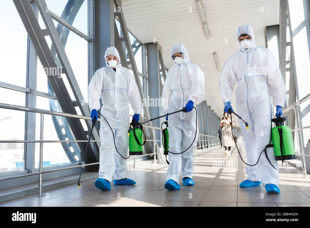 Medical staff wearing protective clothing disinfects the public place Stock Photo