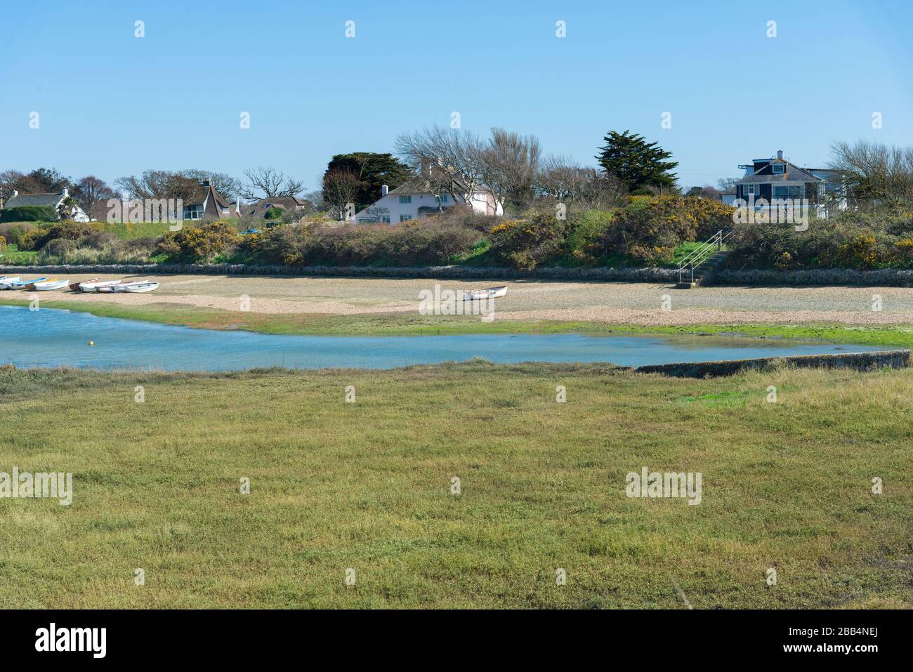 Snowhill Creek at half tide in front of desirable waterfront houses on Roman Landing, West Wittering, Chichester, West Sussex, England, UK Stock Photo