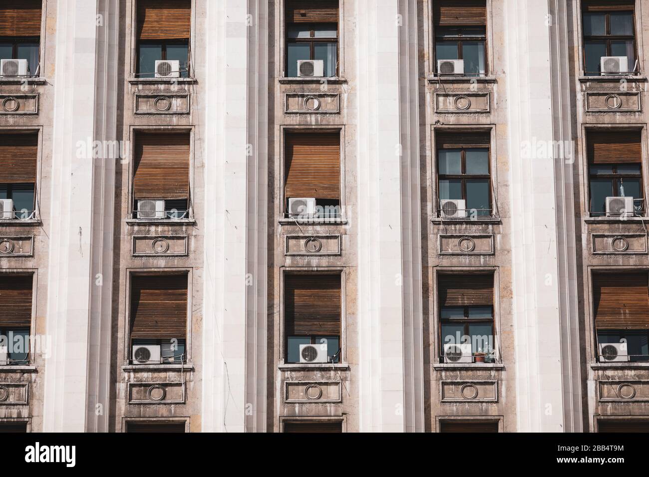 The exterior of an old soviet era style building with window air conditioning machines. Stock Photo