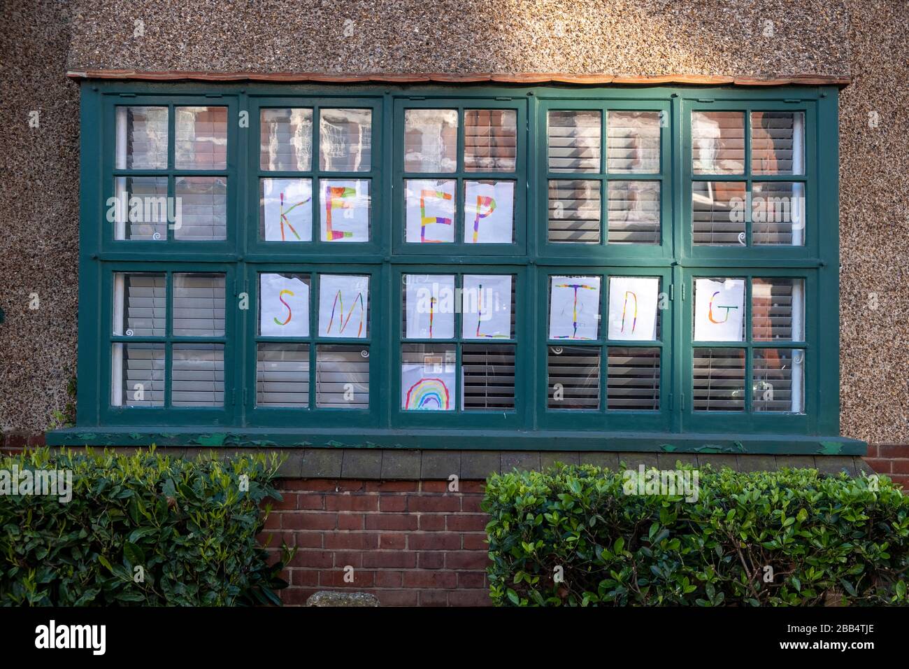 Coronavirus Covid-19 'keep Smiling' sign in a window in Muswell Hill London, 29th March 2020 Stock Photo