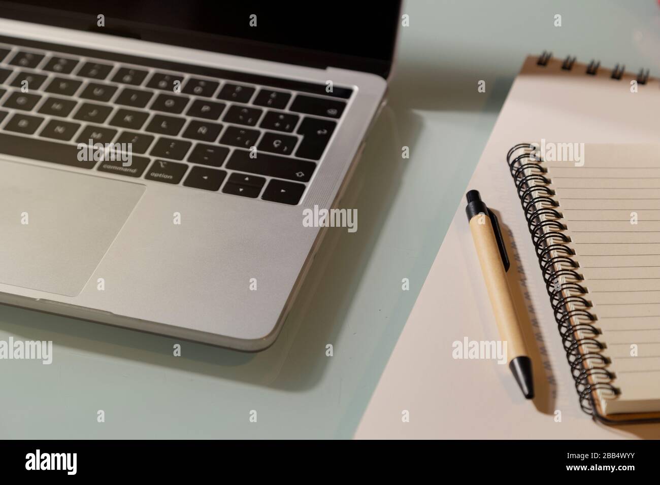Laptop and notepad on the glass table. Top view Stock Photo