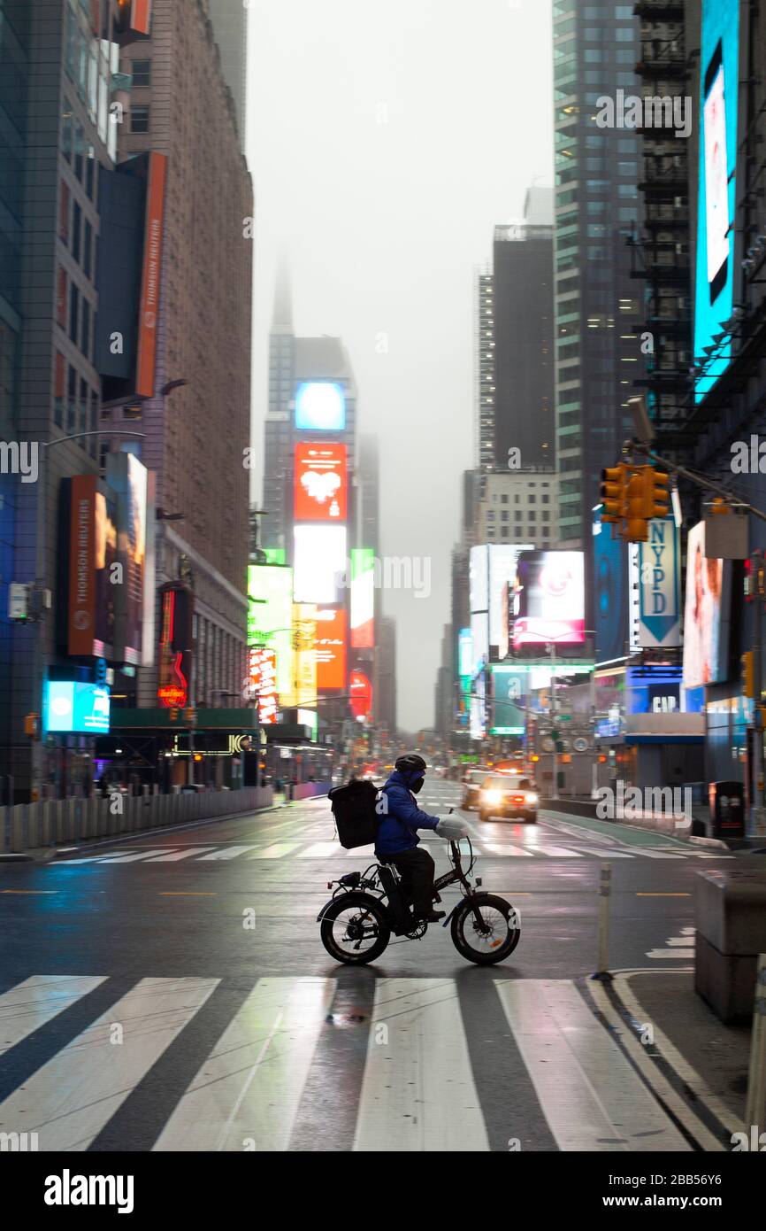 New York Usa 29th March A Bike Messenger Crossing A Largely Empty Times Square On A Rainy Sunday Afternoon During The Covid 19 Corona Virus Lockdown Sunday March 29 In New York
