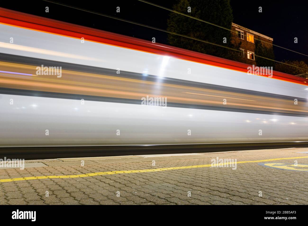 Motion blur of a Virgin Trains Pendolino leaves Coventry station at night Stock Photo