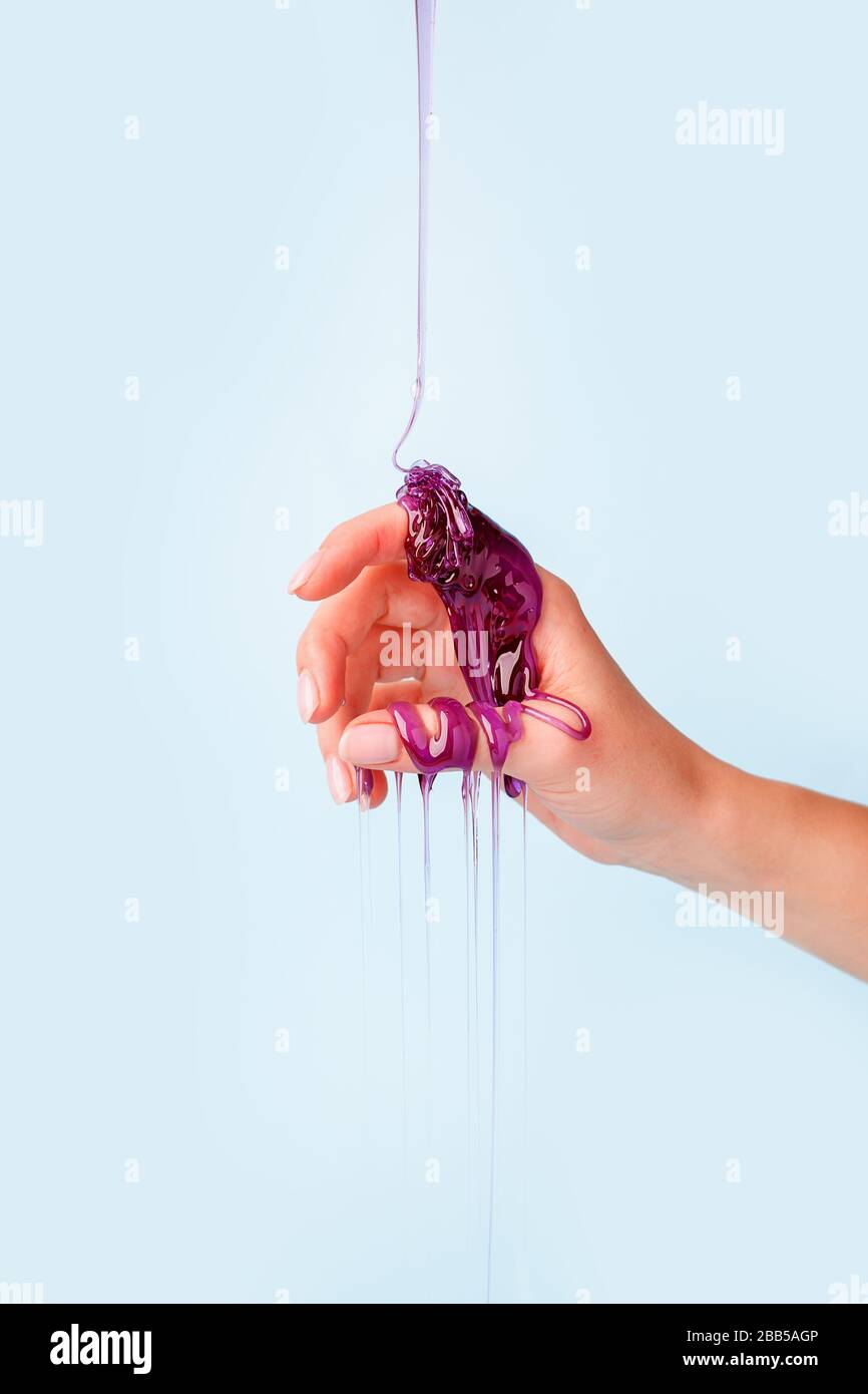 Sweet caramel paste for sugaring purple color on female hand, touch sensative creative idea, hair removal concept, beautician industry, banner flyer c Stock Photo