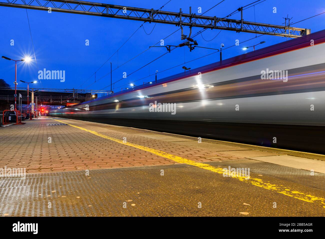 Early morning long exposure view of Virgin Trains Class 390 Pendolino express train arriving at Coventry railway station with a train to London Stock Photo
