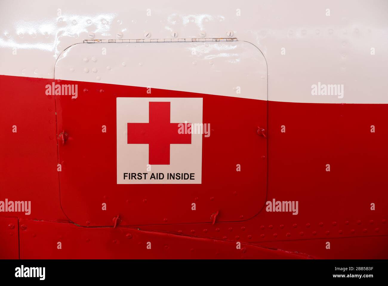 First aid cross and first aid inside title on a metal cabinet door on a aircraft body Stock Photo