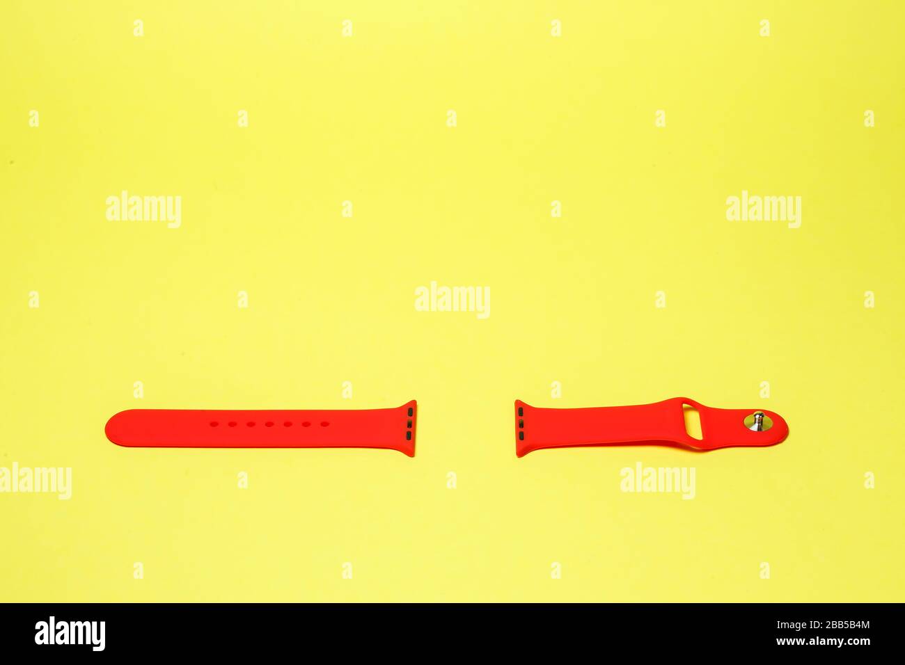 silikone strap for smart watch red color on yelow background Stock Photo