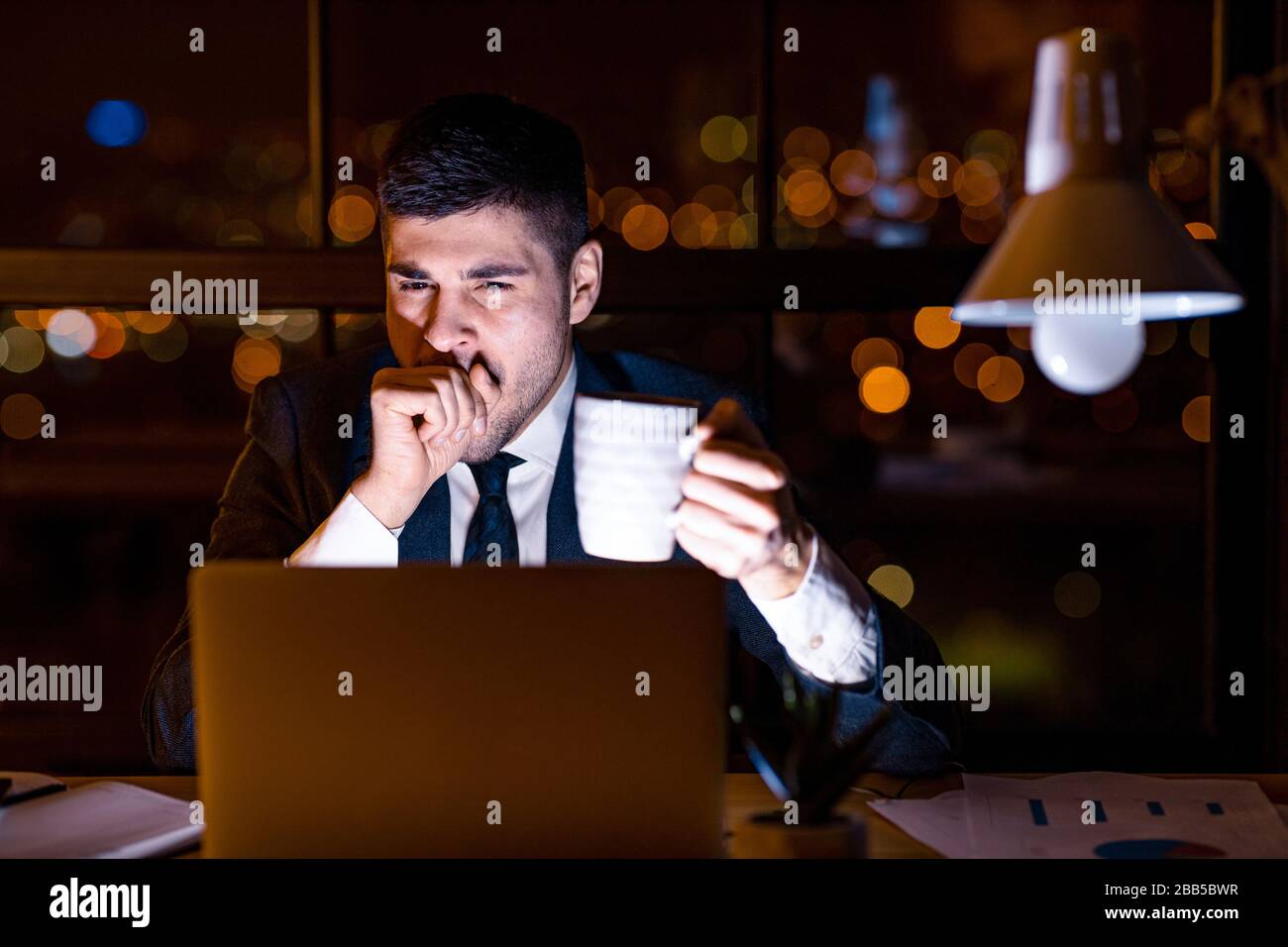 Business Man Yawning Working On Laptop Having Coffee In Office Stock Photo