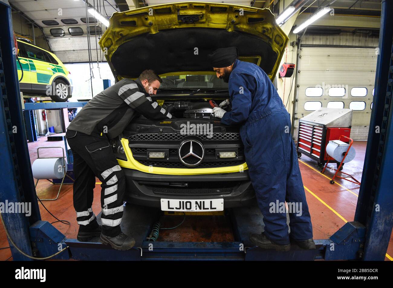 Embargoed to 0001 Tuesday March 31 An NHS mechanic and an AA mechanic check the engine of an ambulance, at the London Ambulance Service workshop in Fulham, London. Stock Photo