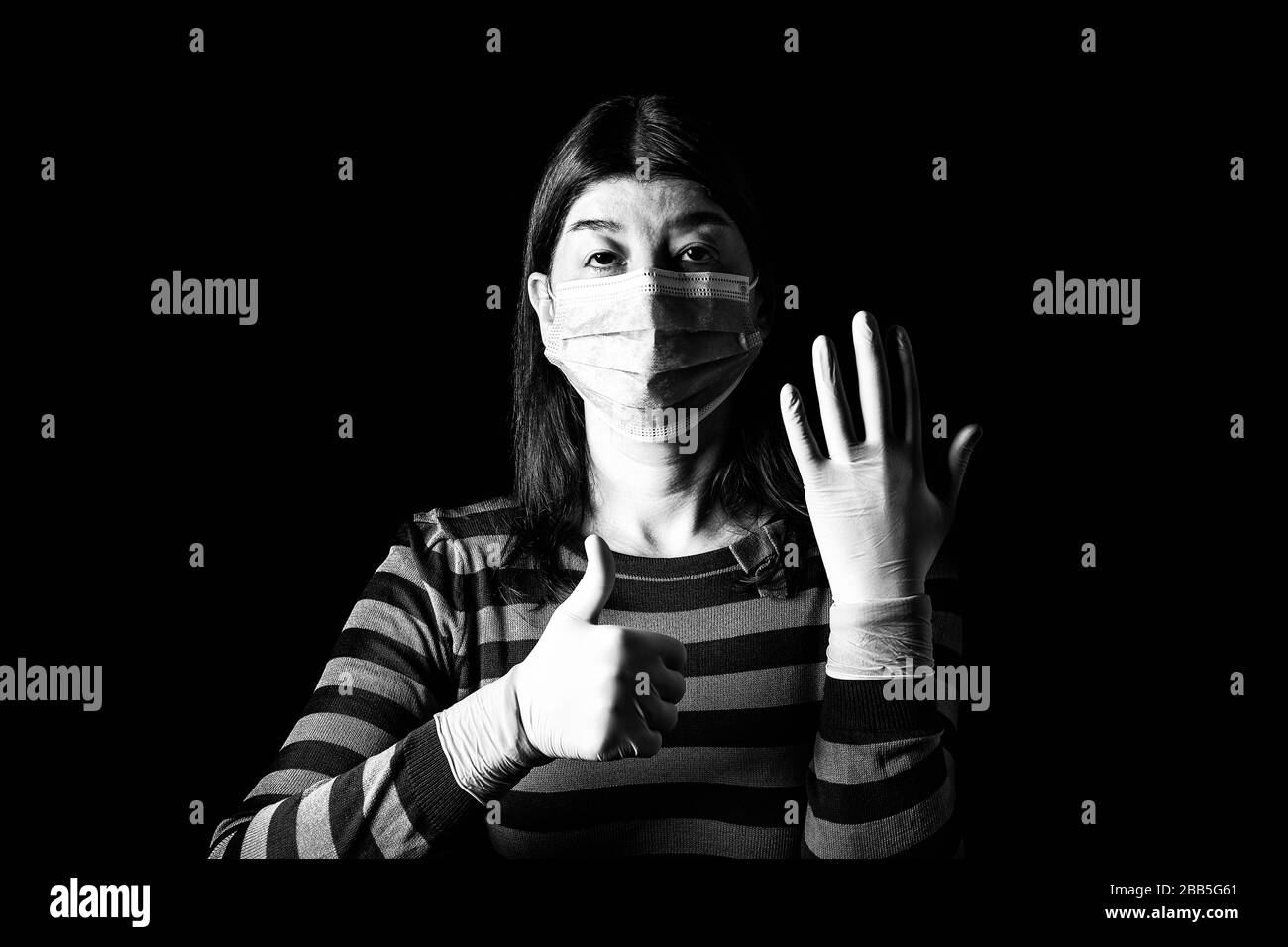 woman with surgical mask, protective gloves and thumbs up. Pandemic or epidemic, scary, fear or danger concept. Protection for biohazard like COVID-19 Stock Photo