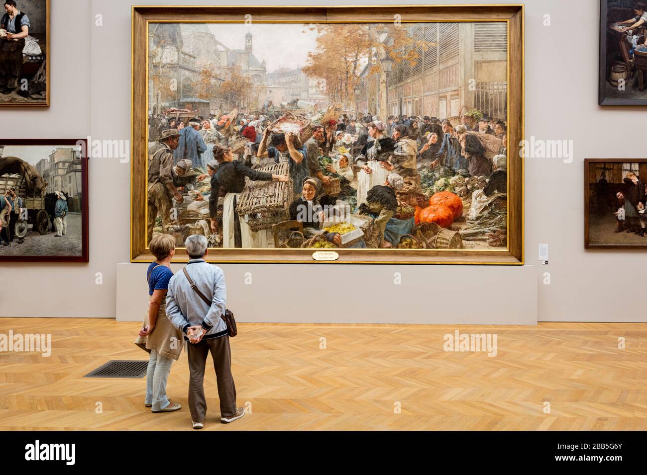 Couple viewing large-scale painting 'Le Halles' by Leon l'Hermitte (1895), on display at Petit Palais, Paris, France Stock Photo