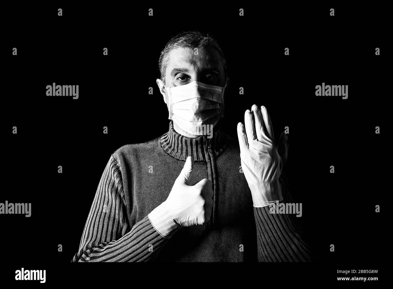 Man with surgical mask, protective gloves and thumbs up. Pandemic or epidemic, scary, fear or danger concept. Protection for biohazard like COVID-19, Stock Photo
