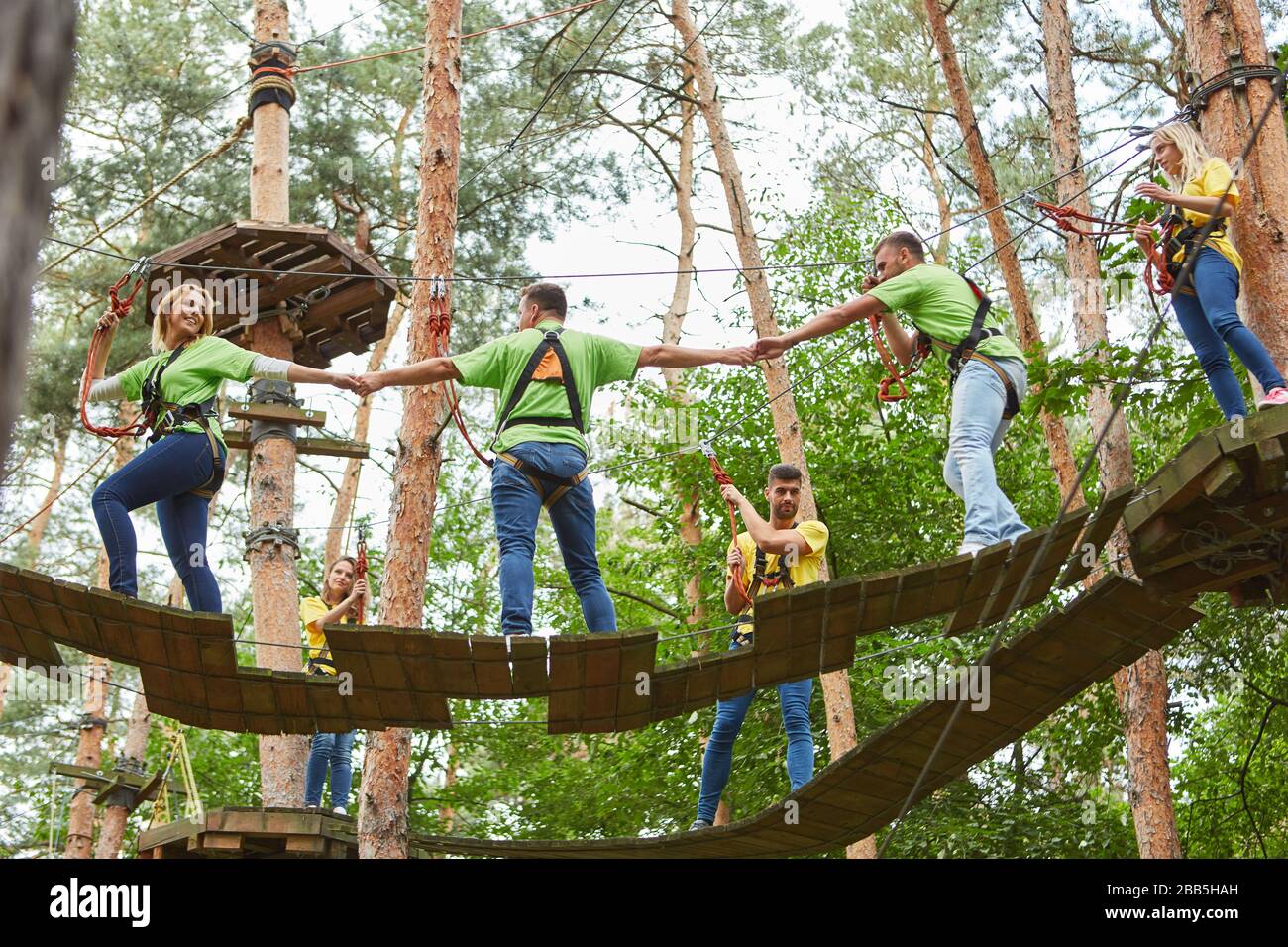 Group climbing in the high ropes course as a team building activity in  summer Stock Photo - Alamy