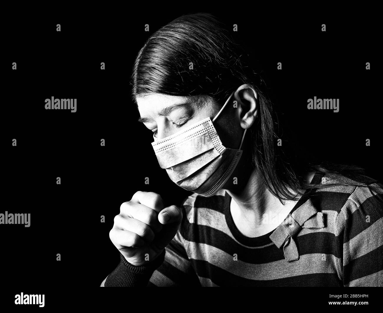 Woman with surgical mask sneezing or coughing. Pandemic or epidemic and scary, fear or danger concept. Protection for biohazard like COVID-19 aka Coro Stock Photo
