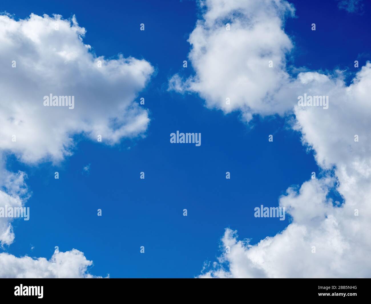 puffy white clouds on a bright blue sky Stock Photo