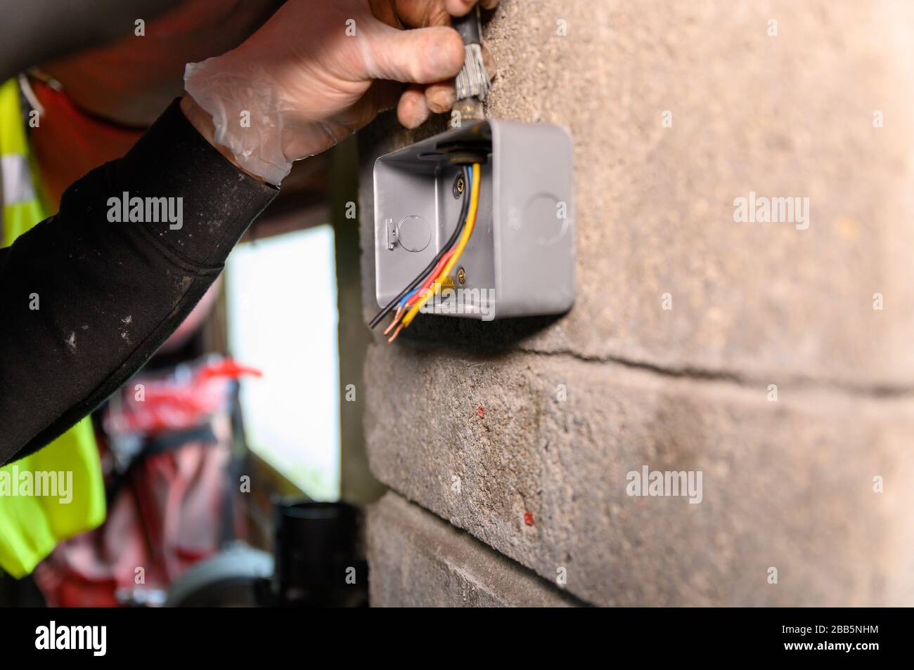 Male electrician feeding wire through socket housing ready for socket