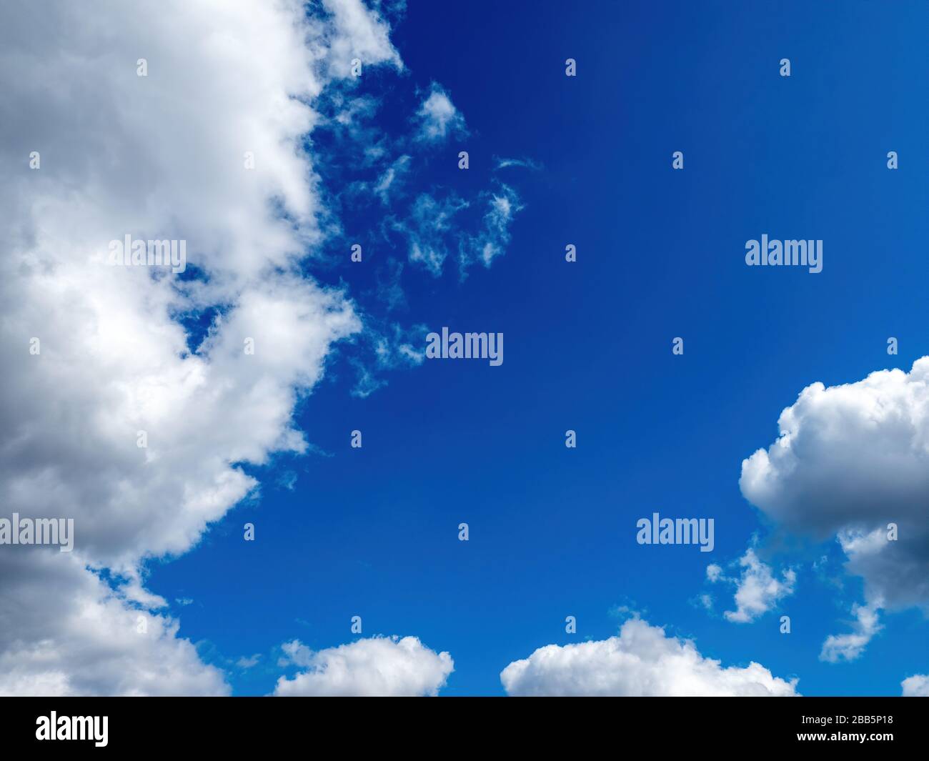 puffy white clouds on a bright blue sky Stock Photo