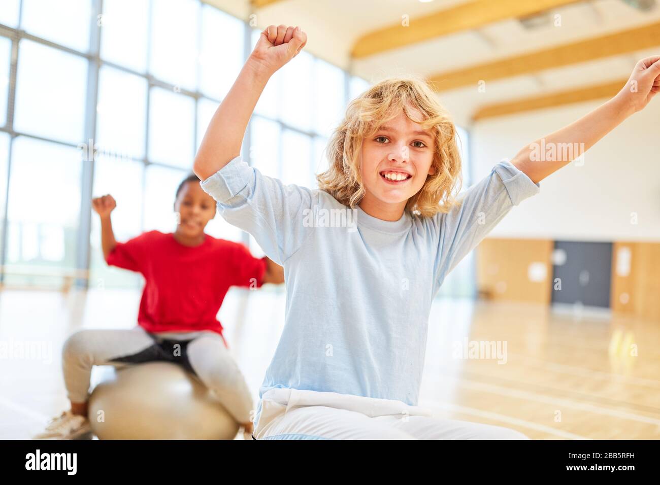 Two children in elementary school have physical education in sports hall Stock Photo