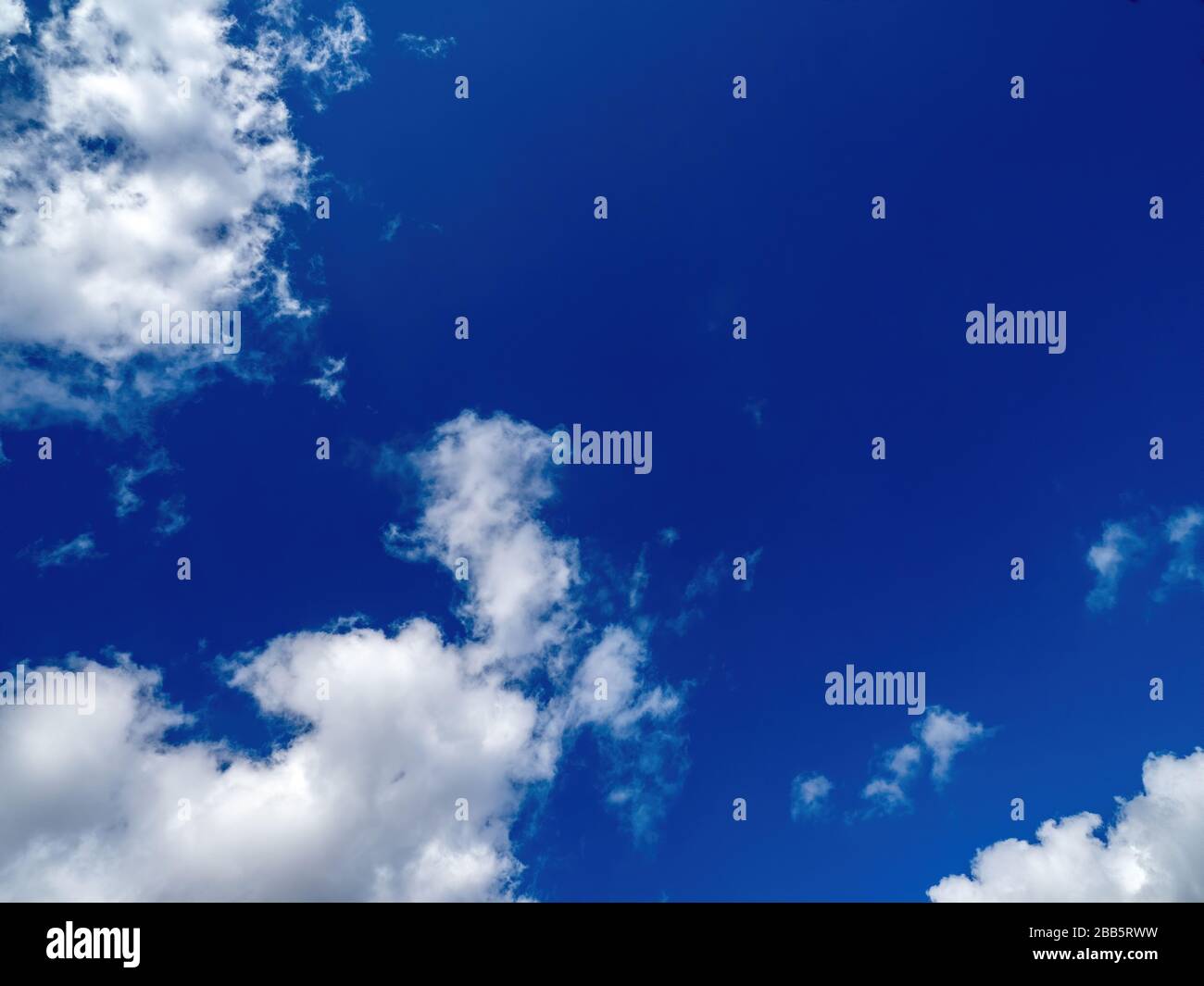puffy white clouds on a bright blue sky Stock Photo