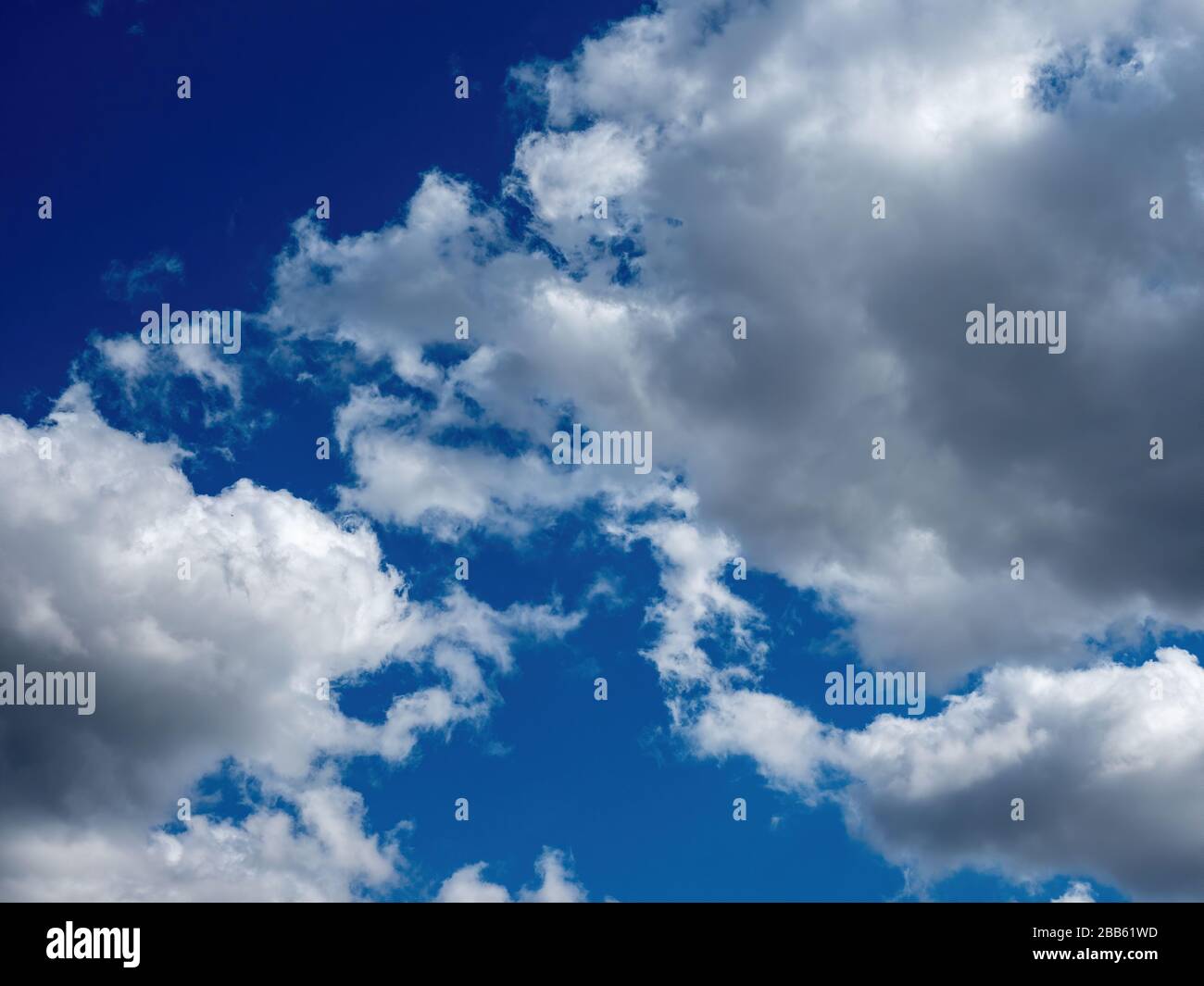puffy white clouds on a bright blue sky Stock Photo - Alamy