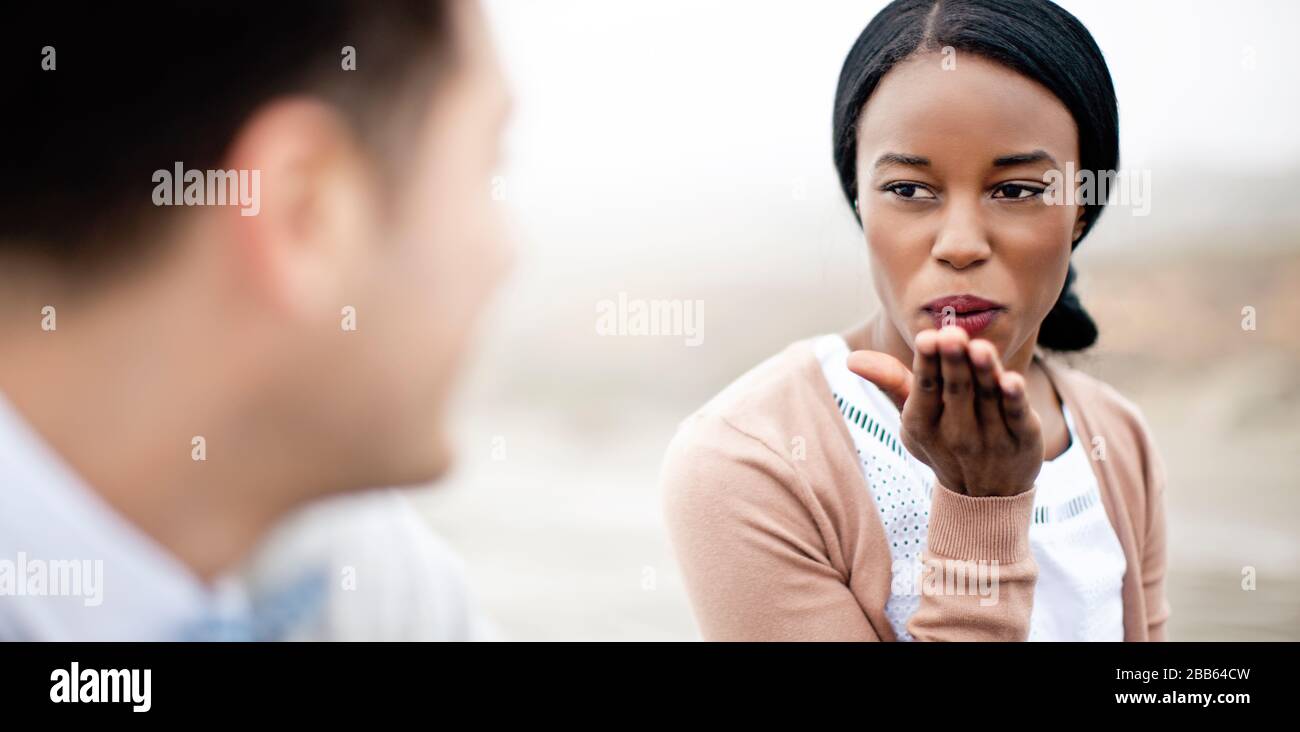 Young woman blowing a kiss at a young man Stock Photo - Alamy