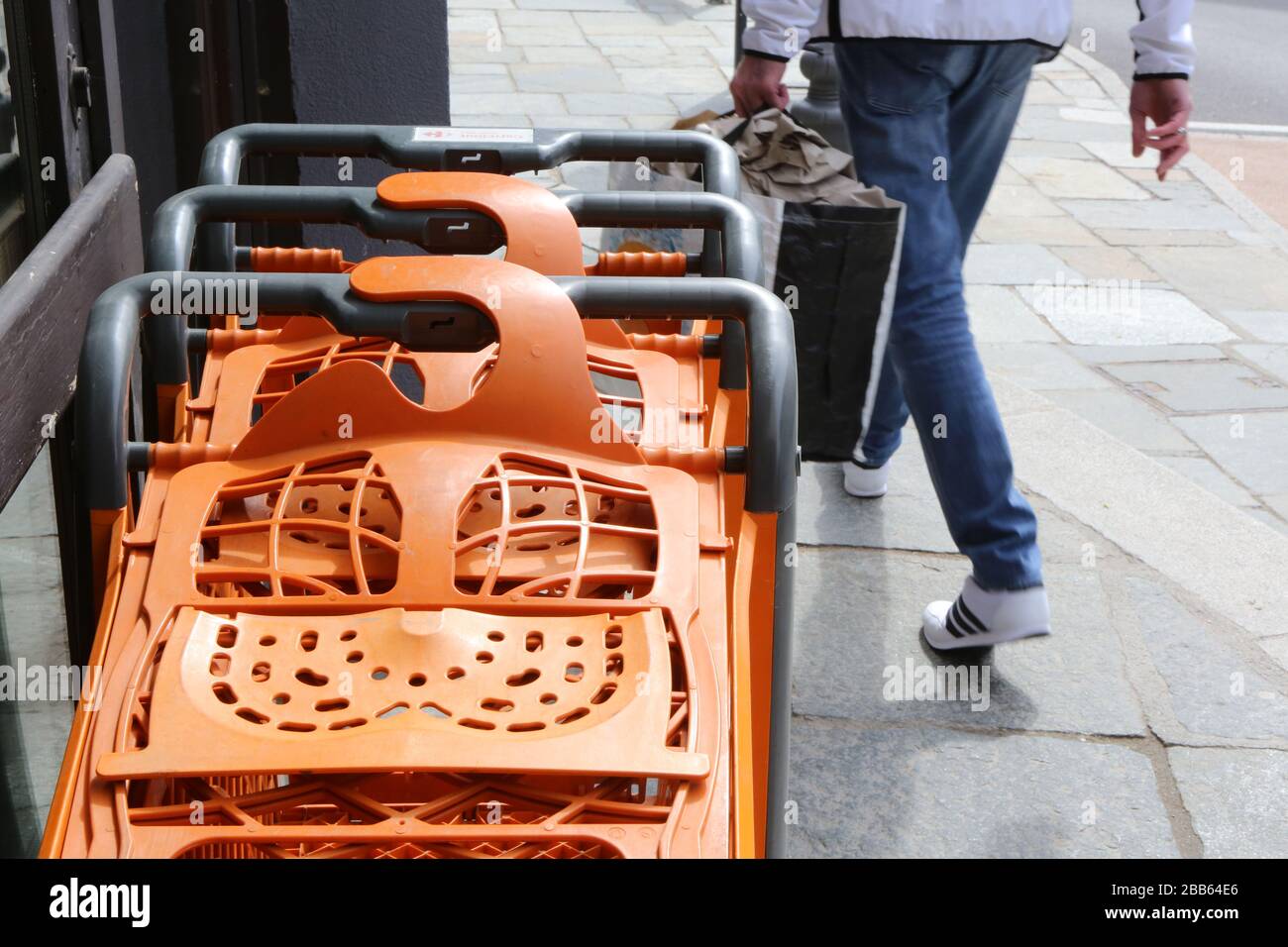 Caddies orange alignés le long de la façade d'un supermarché. Saint-Gervais-les-Bains. Haute-Savoie. France. Stock Photo
