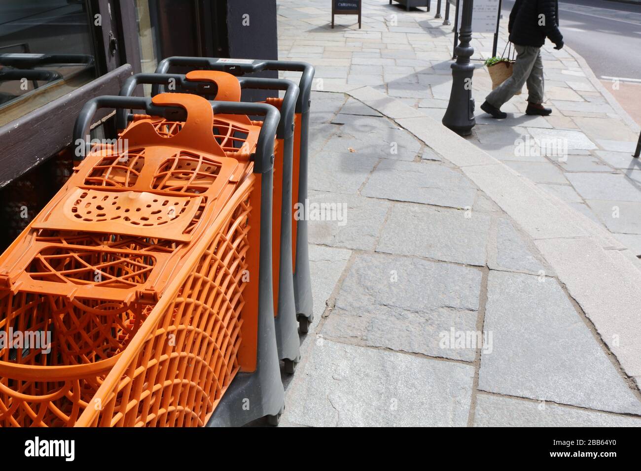 Caddies orange alignés le long de la façade d'un supermarché. Saint-Gervais-les-Bains. Haute-Savoie. France. Stock Photo