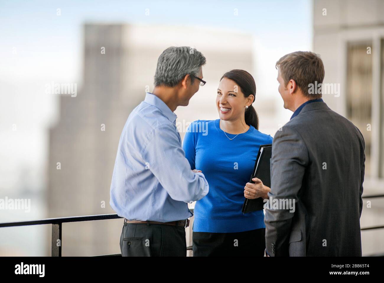 Business colleagues talking on an office balcony. Stock Photo