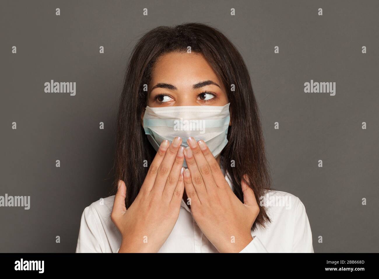 Panicking diseased African American woman in face mask. Epidemic and virus protection concept Stock Photo
