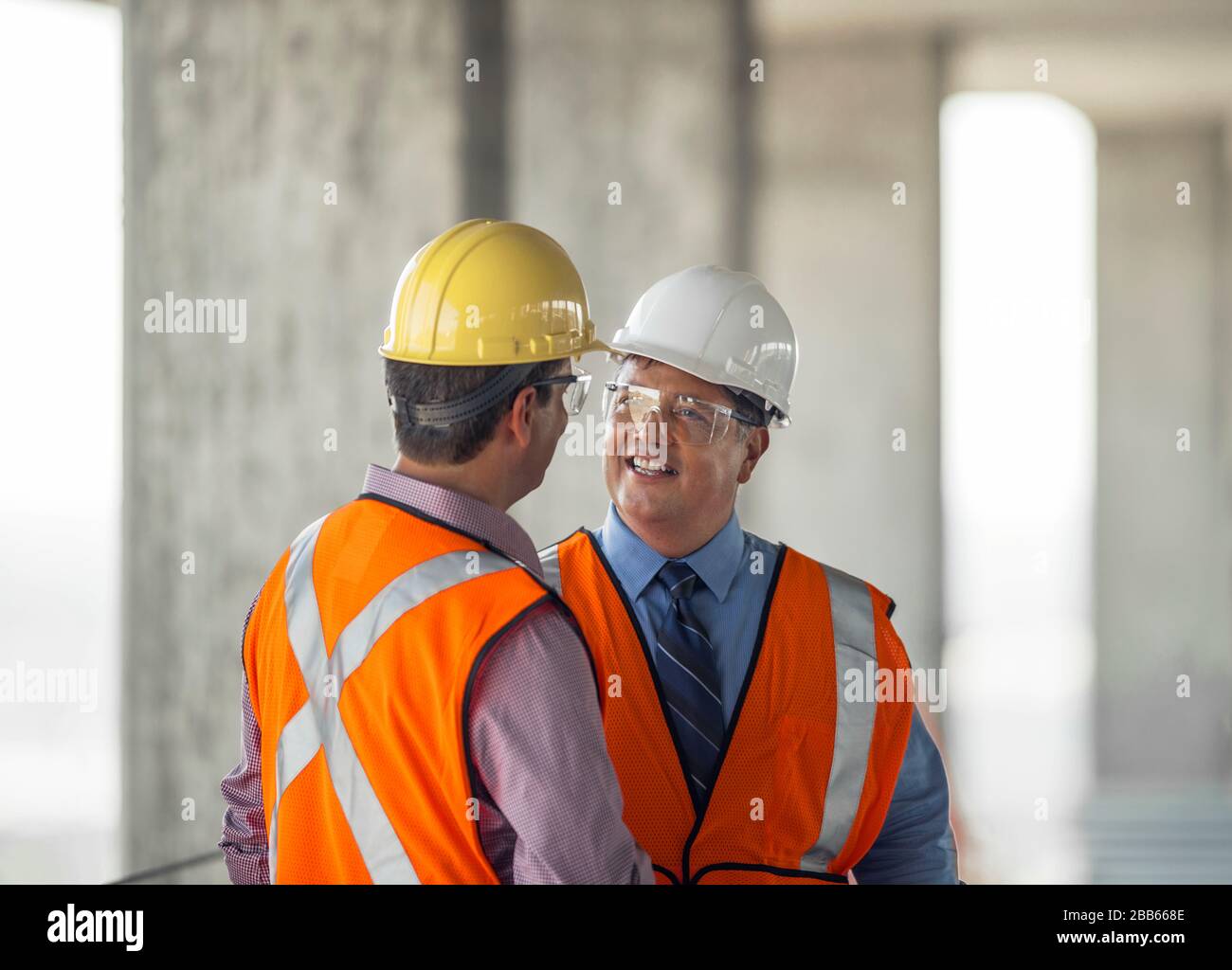 Two construction managers talking on building site Stock Photo - Alamy