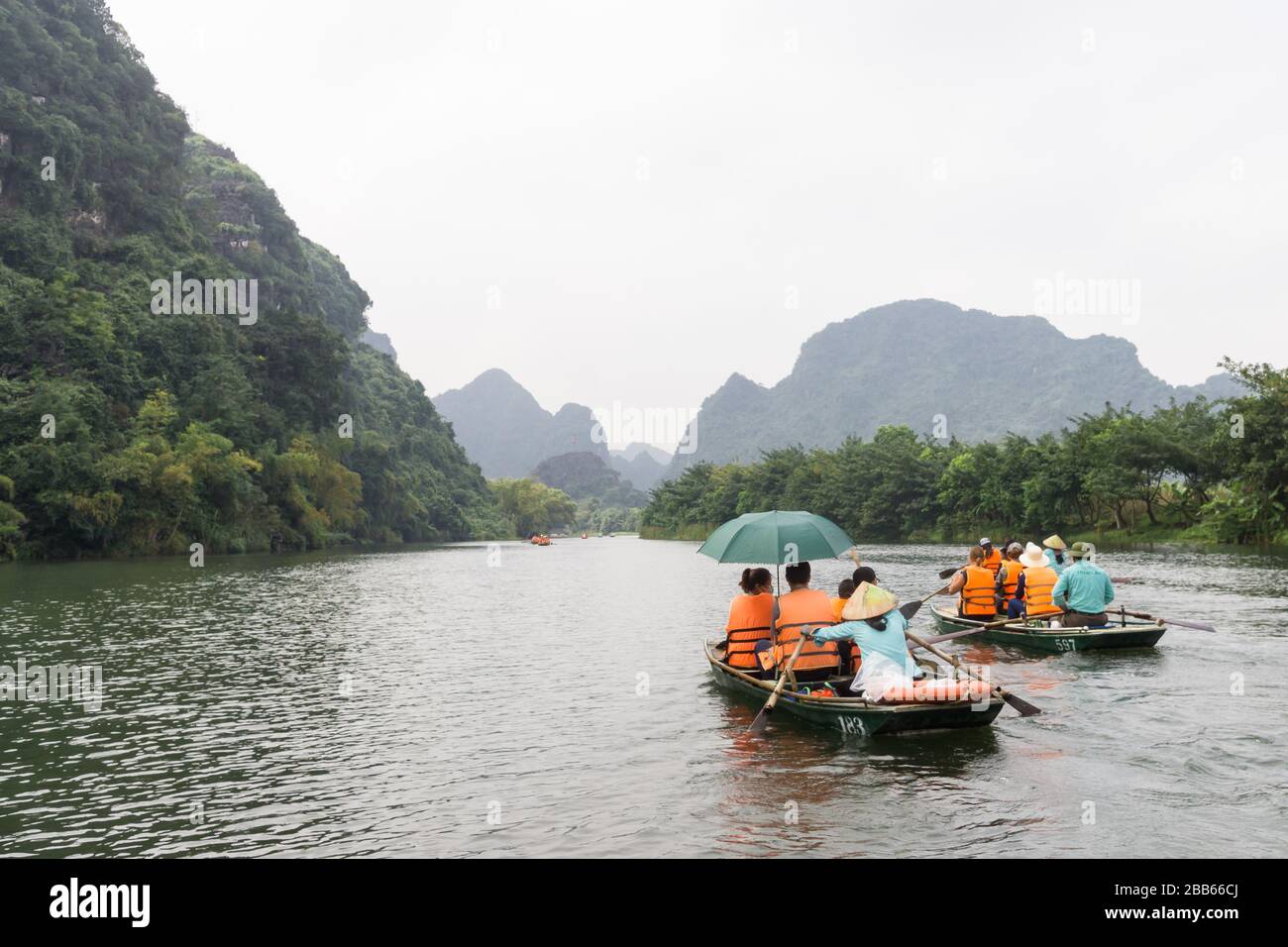 Vietnam Trang An Landscape Complex - Rowboats with tourists enjoying the landscape in Trang An in Ninh Binh Province of North Vietnam. Stock Photo