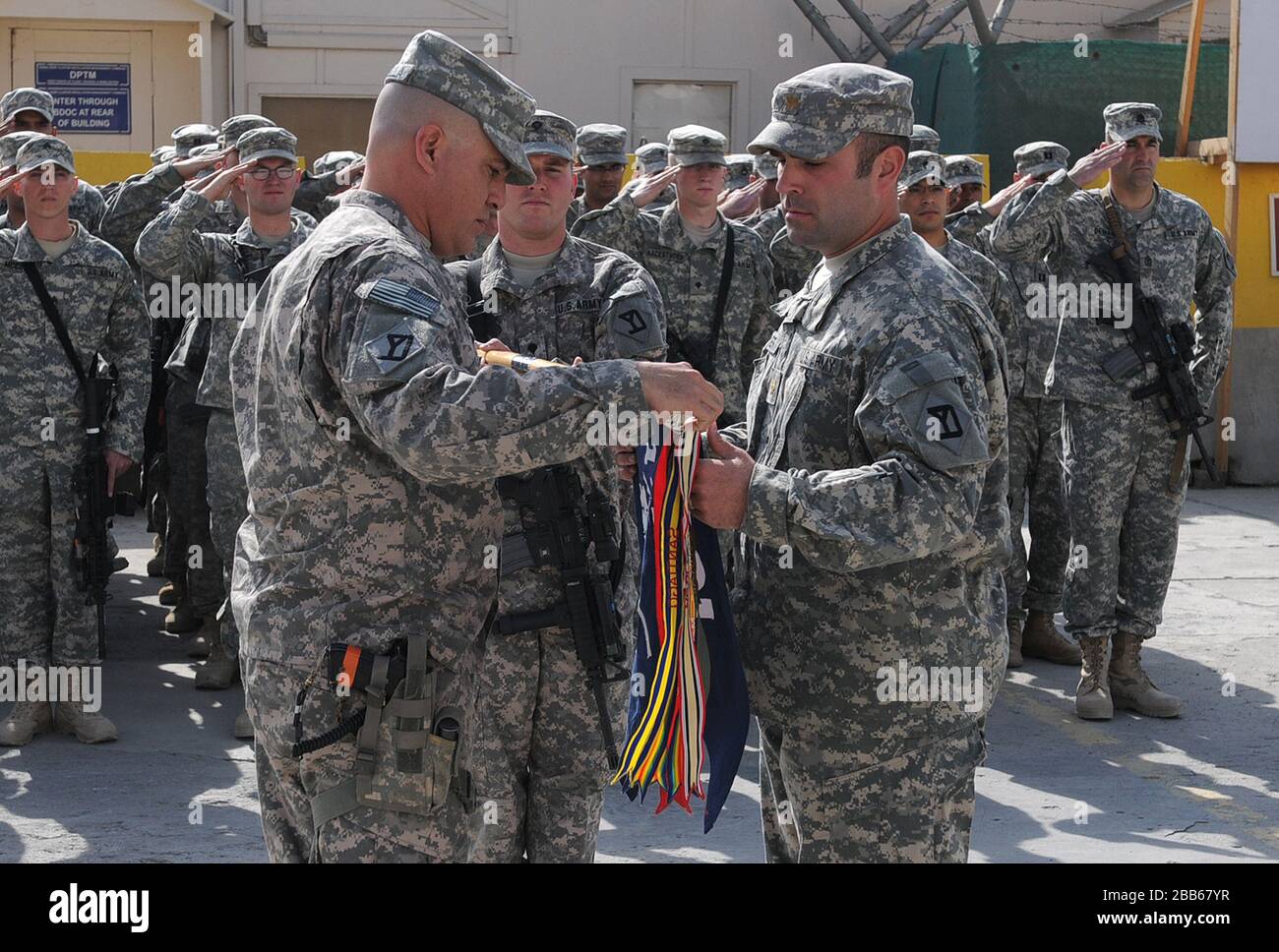 'English: Maj. Timothy Sawyer, right, commander of Headquarters and Headquarters Company (HHC), 1st Battalion, 181st Infantry Regiment, and 1st Sgt. David Parella, senior noncommissioned officer of HHC, uncase the guidon for the Massachusetts Army National Guard unit during a transition of authority ceremony Nov. 4, 2010, at Camp Phoenix in Kabul, Afghanistan. The 1-181st assumed the duties and responsibilities of the 1-178th Field Artillery Battalion, South Carolina Army National Guard, to provide force protection and security for a number of bases throughout the capital city of Kabul, as wel Stock Photo