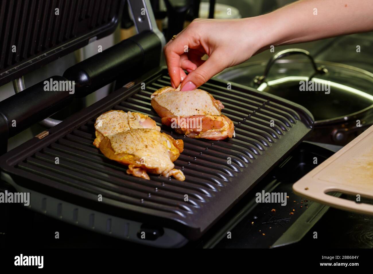 grilling chicken with spices on the electric grill in the home kitchen  Stock Photo - Alamy