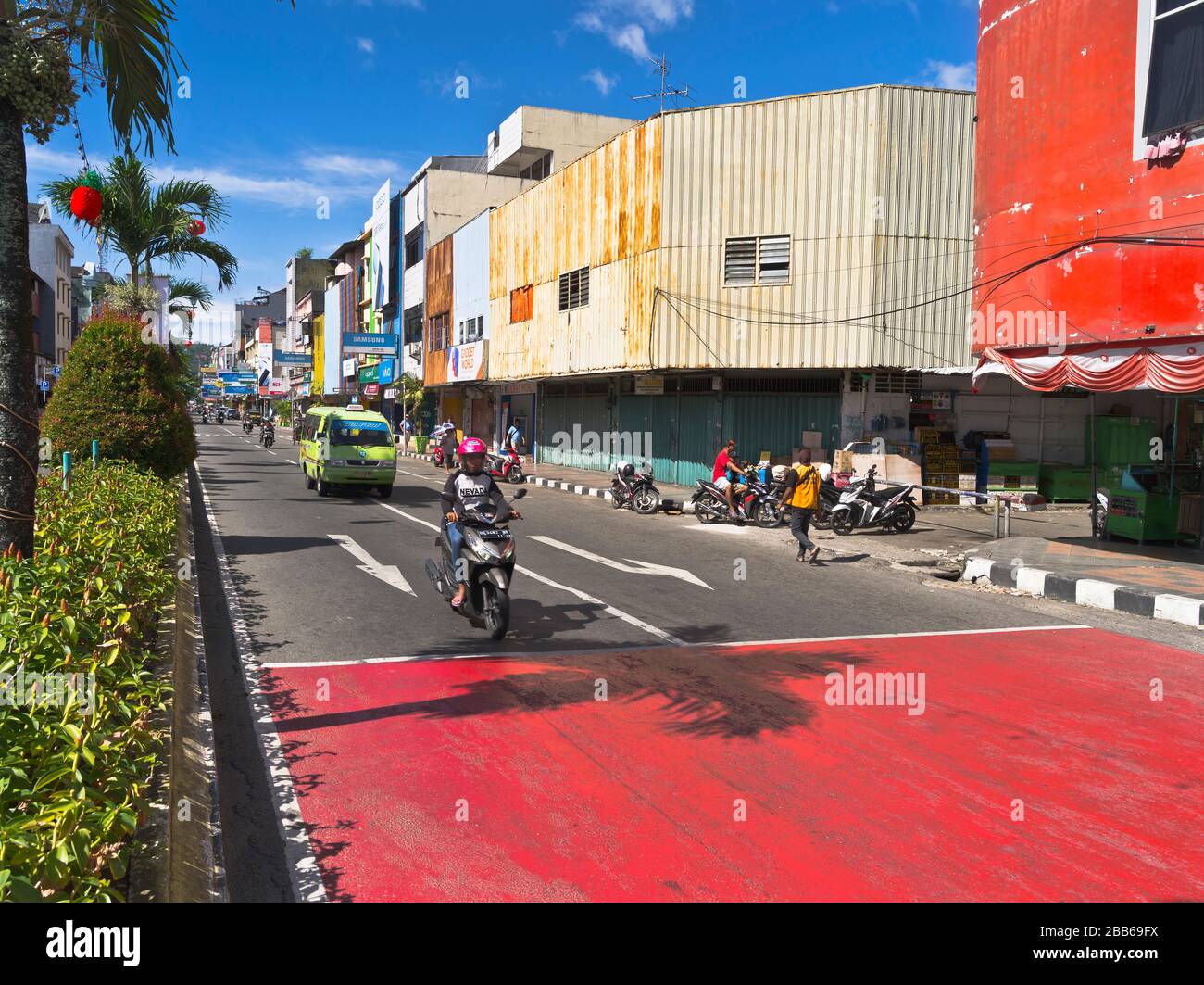 dh indonesian city traffic AMBON MALUKU INDONESIA Street buildings motorbike road on scooter Stock Photo