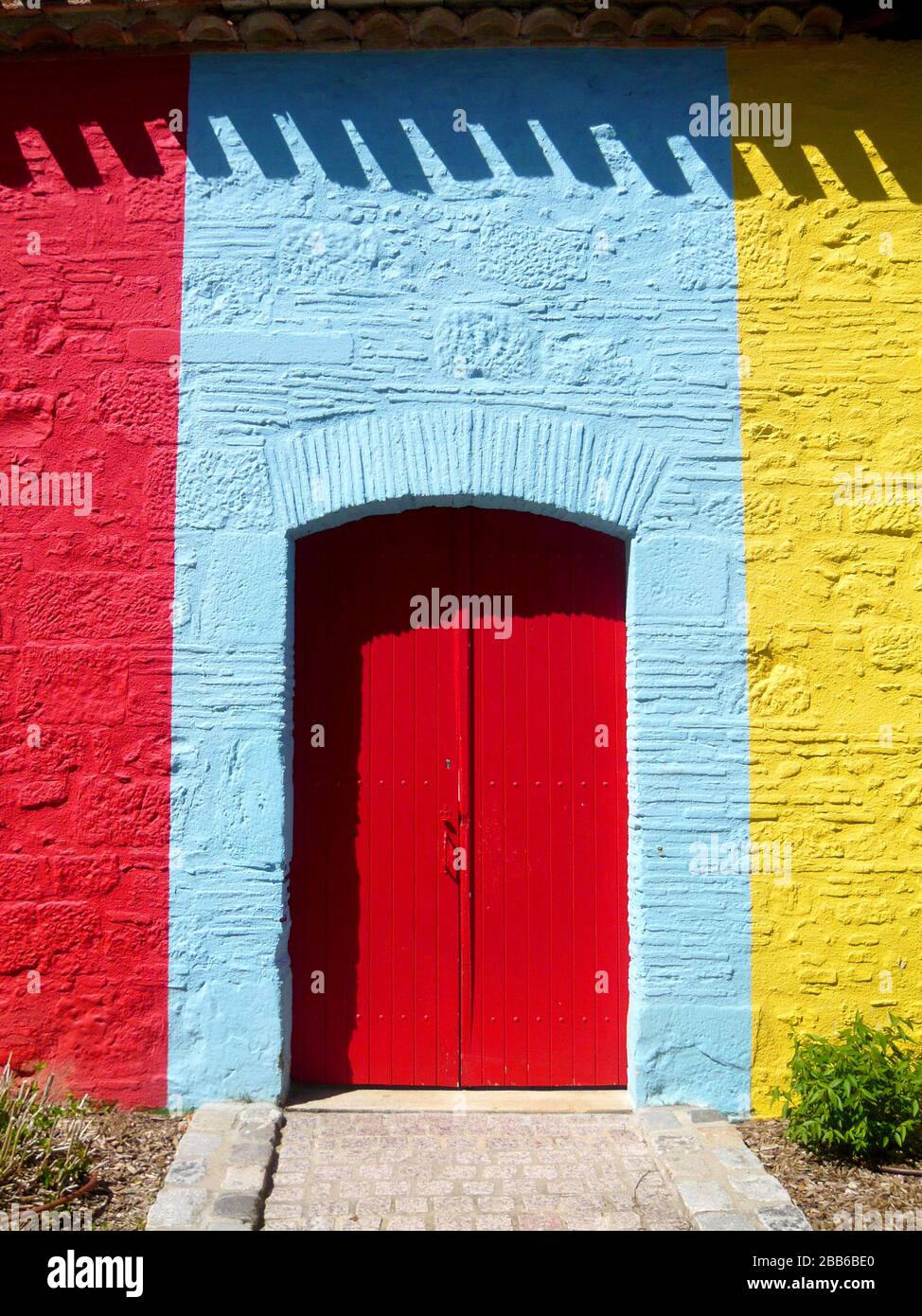 Red door in coloured wall Stock Photo