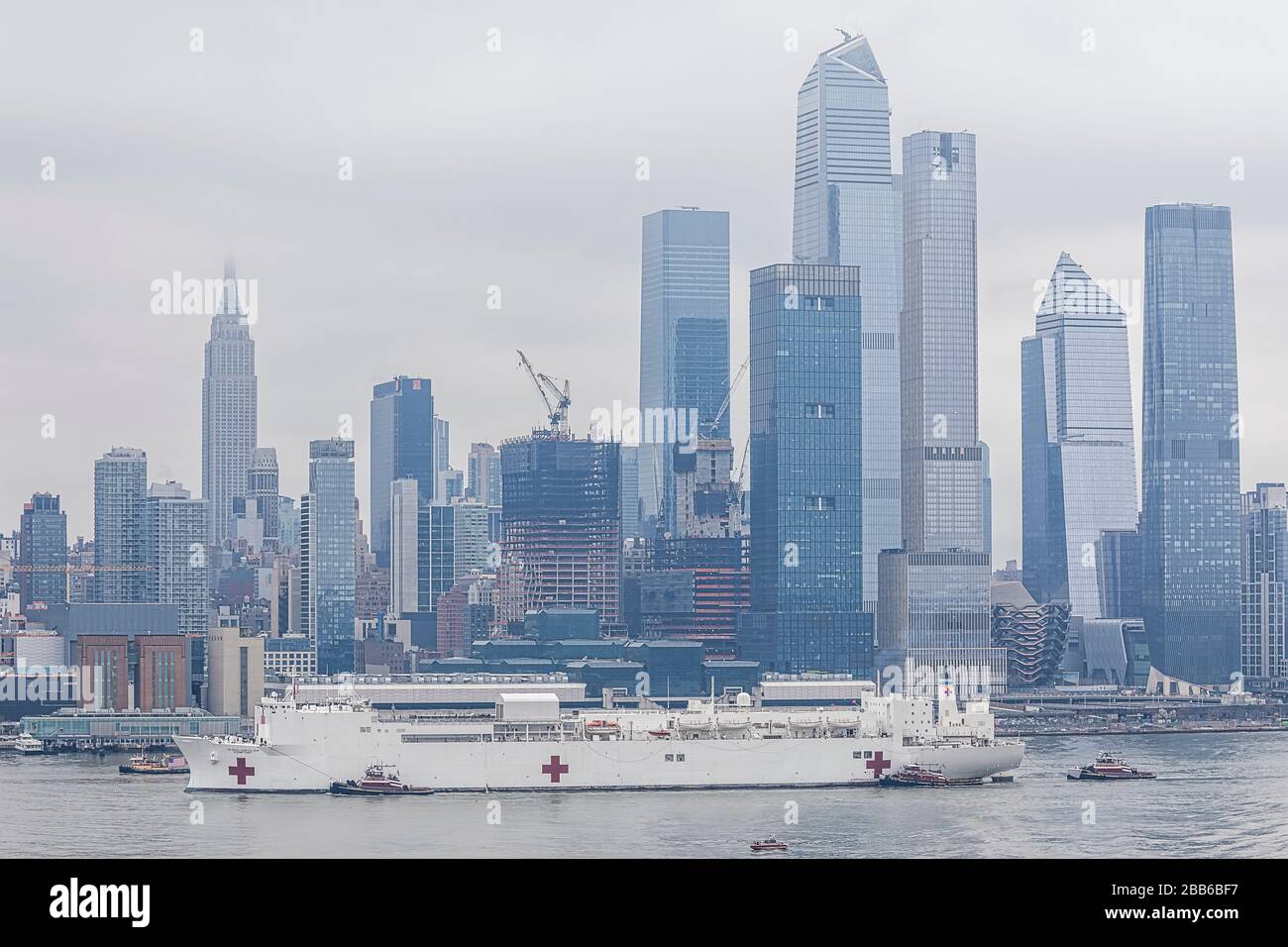 USNS Comfort NYC - Mother nature added to the somber mood as the US Naval Hospital Ship Comfort  arrives in Manhattan in New York City. Seen here the Stock Photo