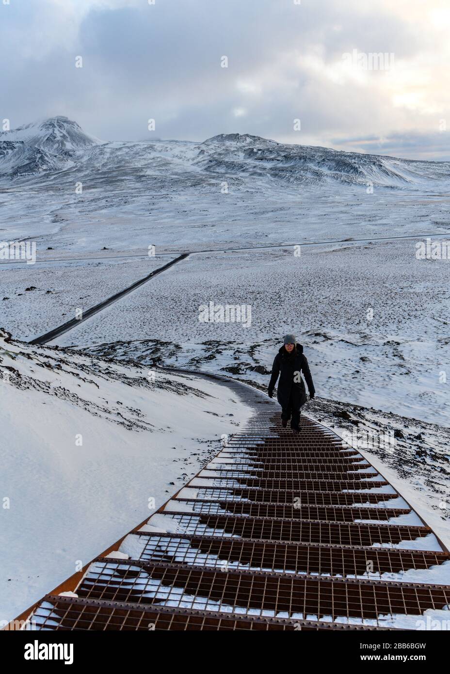 Woman walking up steps to Saxholar Crater, Snaefellsjokull National Park, Snaefellsnes Peninsula, Iceland Stock Photo