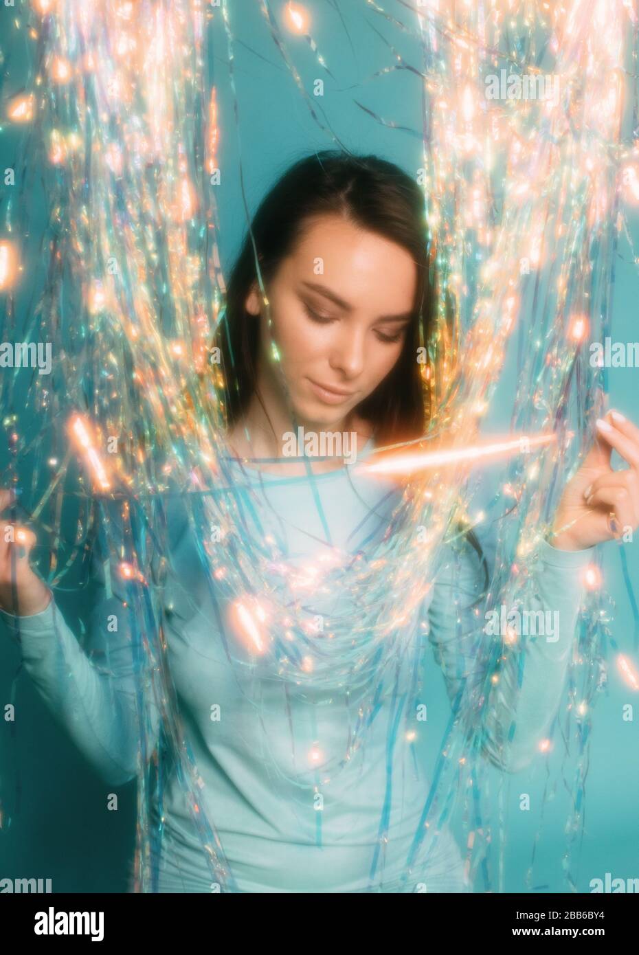 Portrait of a beautiful woman playing with a tinsel curtain Stock Photo