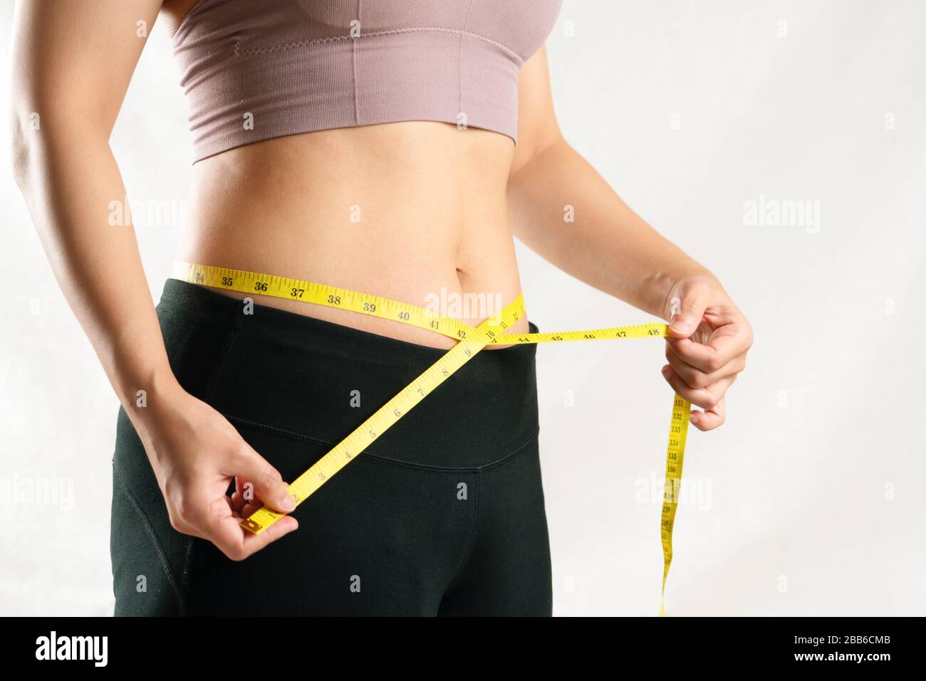 https://c8.alamy.com/comp/2BB6CMB/young-woman-measuring-her-belly-waist-with-measure-tape-woman-diet-lifestyle-concept-2BB6CMB.jpg