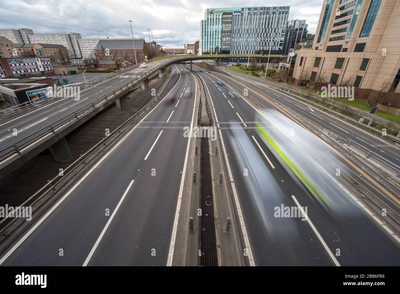 Glasgow, UK. 30th Mar, 2020. Pictured: The M8 Motorway which passes over the Kingston Bridge, Scotland's business bridge, is seen with free light and free flowing traffic which would normally otherwise be gridlocked in a traffic jam. The Kingston Bridge normally handles 150,000 vehicles per day under normal operations, however due to the lockdown imposted by the UK government, the number of vehicles has dwindled considerably. Credit: Colin Fisher/Alamy Live News Stock Photo