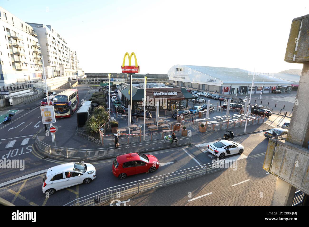 Brighton, UK. 23 March 2020 McDonalds drive-thru customers queuing in there cars shortly before the fast food restaurant closes itÕs doors due to the Coronavirus Outbreak. Credit: James Boardman / Alamy Live News Stock Photo